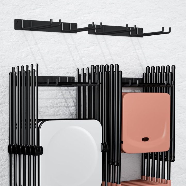 Two black wall-mounted racks holding folding chairs
